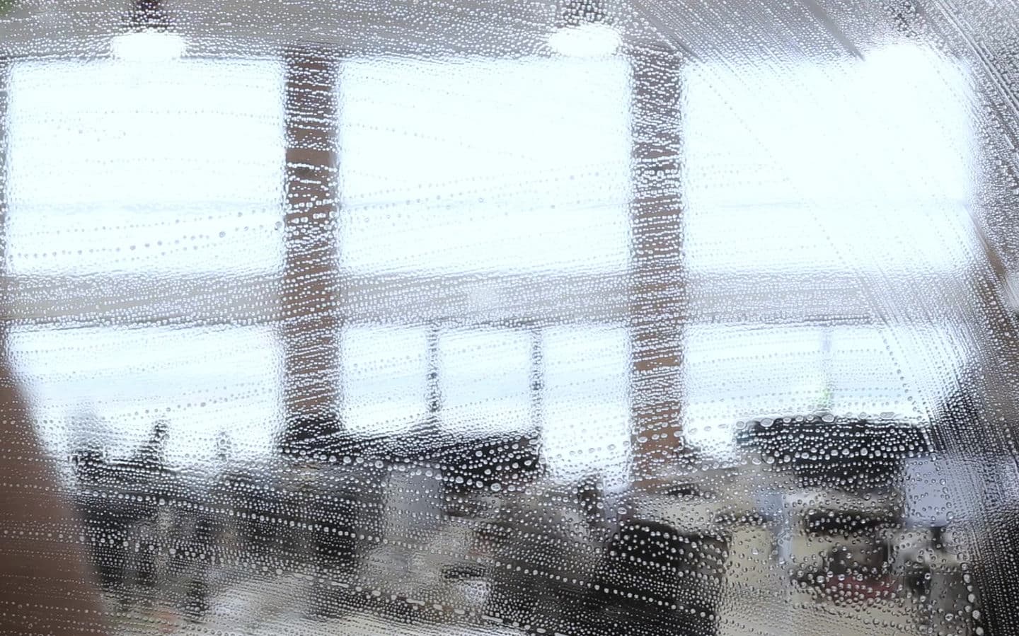 Close-up of water beading and rinsing clean off a freshly washed window